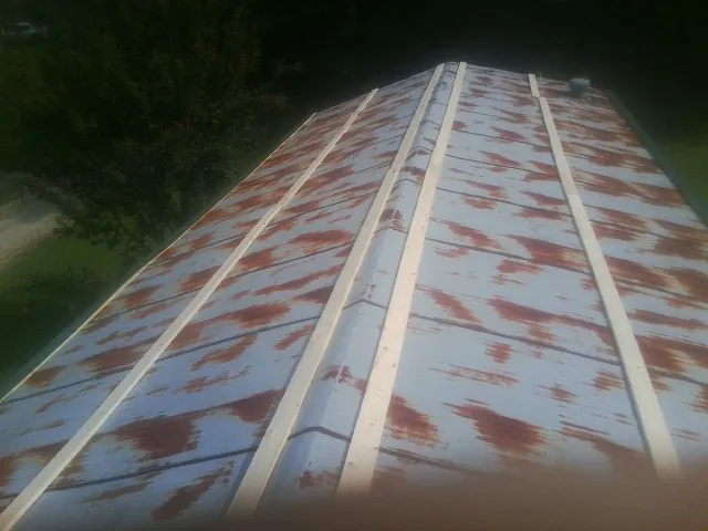 Rusted metal roof panels with new wood purlins before replacement — Storm Damage Roof Repair in Cobbs Creek by Roofing Brothers