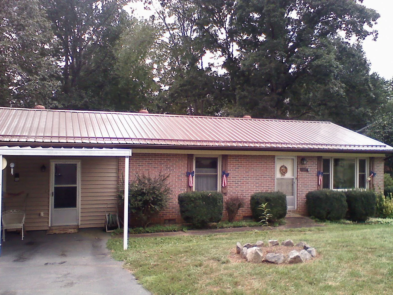 Bronze metal roof and carport on a brick ranch home — Roof Repair work by our crew in Cobbs Creek
