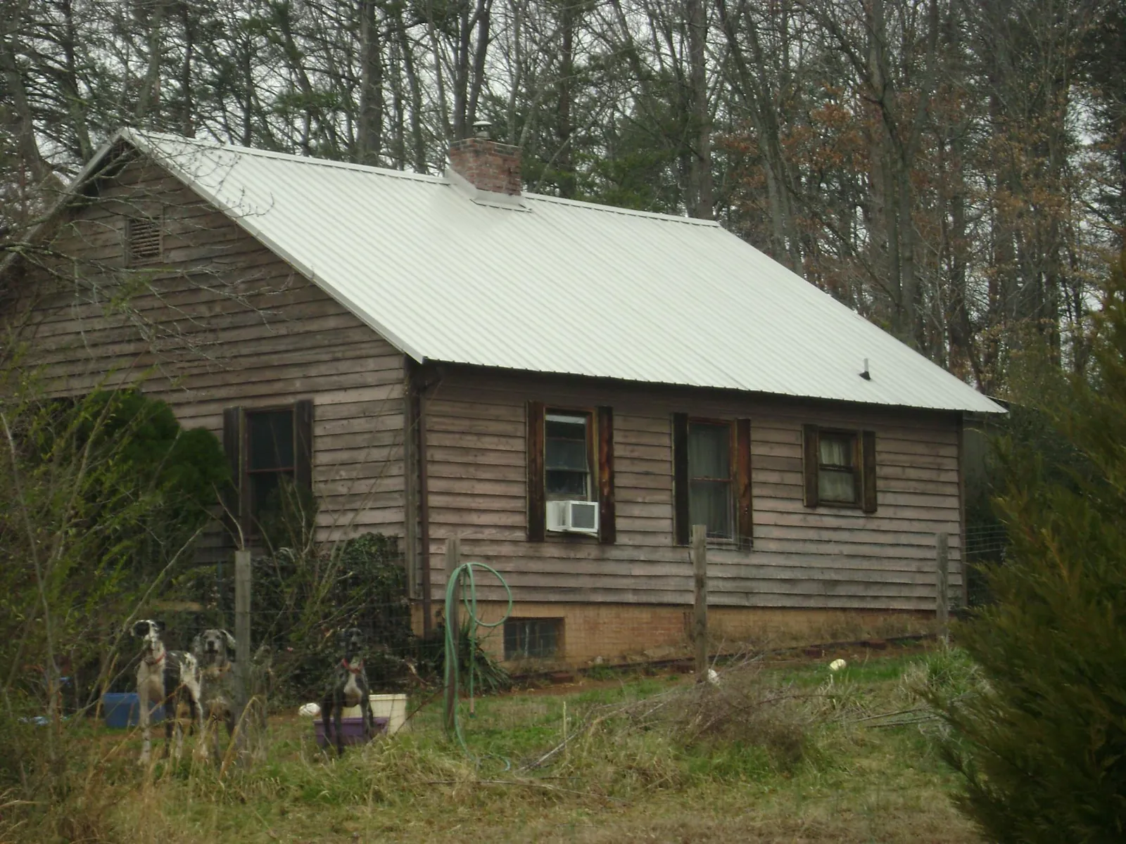 White metal roof on an old wood sided farmhouse, from a Metal Roof Installation job in Cobbs Creek